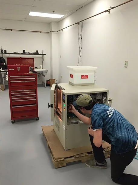Service Tech working on test chamber by associated environmental systems