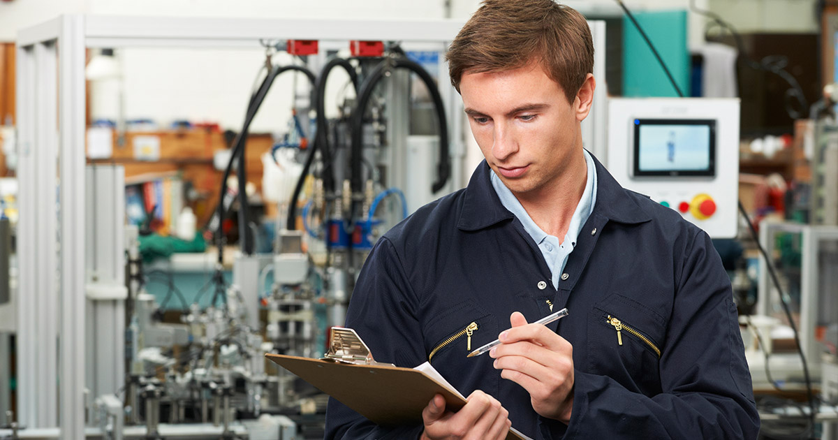 Engineer Writing On Clipboard In Factory